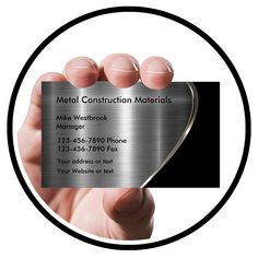 a hand holding a metal business card in front of a circle