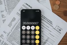 a calculator sitting on top of some papers and coins next to it is money