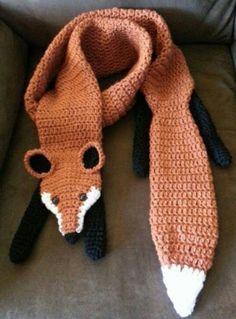 a knitted scarf with a fox head on it sitting on top of a couch