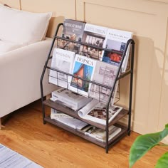 a magazine rack sitting on top of a hard wood floor next to a white couch