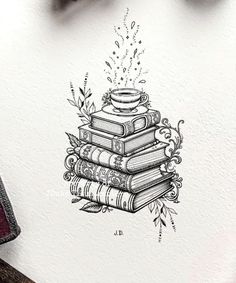 a stack of books sitting on top of a table next to a pen and ink