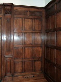 an empty room with wood paneling on the walls