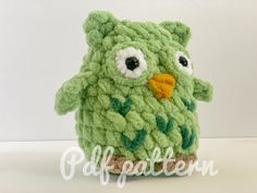 a green crocheted stuffed animal with big eyes and leaves on it's body