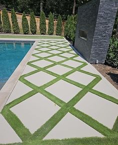 an outdoor swimming pool with artificial grass on the ground and in between it's walls