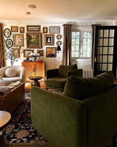 a living room filled with furniture and pictures on the wall