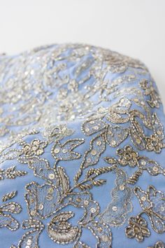 a blue and silver brocade on a white surface