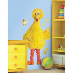 a child's room decorated in yellow and blue with a sesame character on the wall