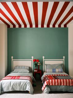 two beds in a room with green walls