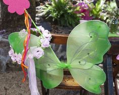 a green butterfly decoration sitting on top of a wooden bench