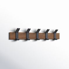 a wall mounted coat rack with five hooks