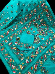 Gorgeous Turquoise Color saree with handwoven Kantha stitch work in Mutli color.  Please note - The edging on the pallu end is done by the weaver with the same kantha stitch work and not done with machine.  Item: Saree Color : Turquoise Color  Base Fabric: Bangalori Silk  Blouse piece : Yes Blouse material: Bangalori Silk  Work: Handloom, Kantha Work  Fall & Edging (Yes/No) : Yes  Occasion: Party, Festival, Traditional, Religious, House-warming. Kindly note : Since this Saree is handmade hence little inconsistencies may be there however it is not considered as a defect. Every Saree is unique in its own way and weavers put in there heart and soul in weaving these beauty. Bollywood Style Embroidered Turquoise Sets, Festive Turquoise Embroidered Sets, Traditional Turquoise Sets For Eid, Turquoise Traditional Wear With Resham Embroidery, Turquoise Sets With Resham Embroidery In Traditional Drape, Traditional Blue Salwar Kameez For Puja, Festive Embroidered Turquoise Sets, Turquoise Saree With Cutdana In Traditional Drape, Bohemian Green Sets For Puja