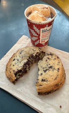 there is a half eaten cookie next to a cup of ice cream on the table