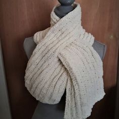 a white knitted shawl draped over a mannequin