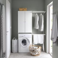 a washer and dryer in a small room with clothes hanging on the rack