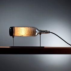 a lamp that is sitting on top of a table next to a light bulb in the shape of a bottle