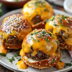 three cheeseburger sliders on a white plate