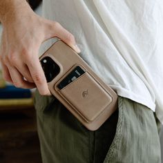 a man is holding his phone in his pocket