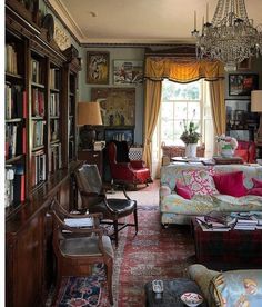 a living room filled with lots of furniture and a chandelier hanging from the ceiling