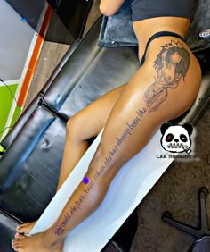 a woman sitting on top of a surfboard with her legs crossed and tattooing