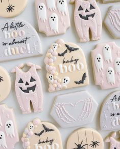 decorated cookies are arranged in the shape of baby clothes and ghostes, with words written on them