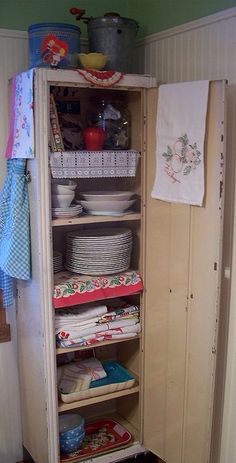 an old cupboard with dishes and plates in it