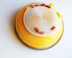 a yellow cake with white icing and nuts on top