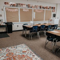 an empty classroom with desks and chairs in front of a bulletin board on the wall