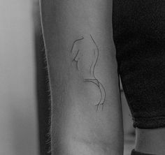 a black and white photo of a woman's arm with a tattoo on it