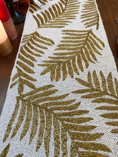 a close up of a rug on a table with candles and flowers in the background