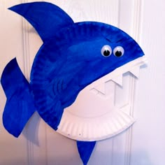 a paper plate shaped like a shark hanging on a door