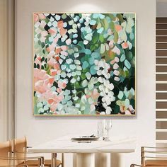 a painting hanging on the wall above a dining room table