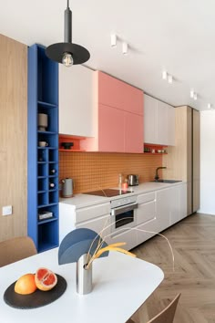 an image of a kitchen setting with oranges on the counter and blue cabinets in the background