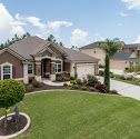 a large house in the middle of a lush green yard