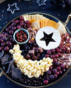 a platter filled with grapes, crackers and cheese