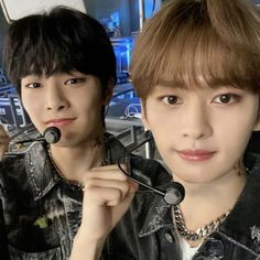 two young men are posing for the camera with their hair combs in front of them