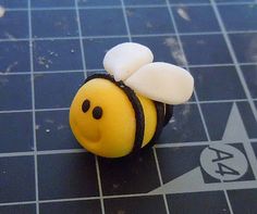 a yellow and black toy with a bee on it's back end sitting on a tiled floor