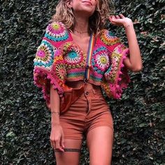 a woman standing in front of a green wall with her hand on her hippie