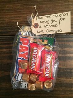 a bag filled with candy on top of a wooden table next to a note that says, thank the jackpot having you for a tache love, george