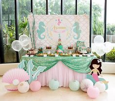 a little mermaid themed birthday party with balloons and dessert table set up for an under the sea theme