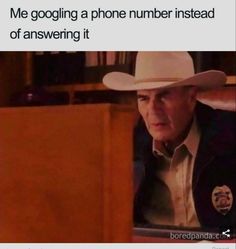 an older man wearing a cowboy hat looking at his cell phone while sitting in front of him