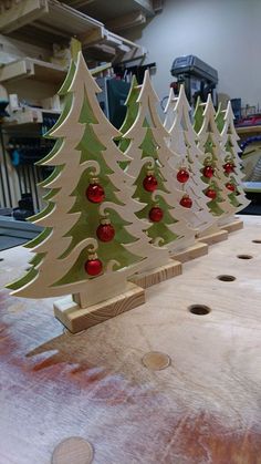 several wooden christmas trees with ornaments on them