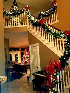 christmas decorations on the banisters and stairs in a home decorated with red, white and green garland