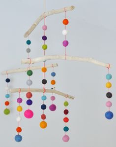 a colorful mobile is hanging from a tree branch with the word hello written on it