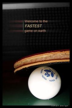 a ping pong paddle sitting on top of a table next to a white ball