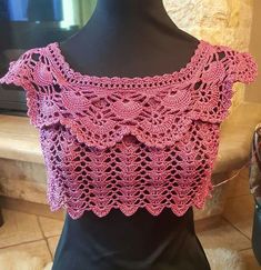 a pink crocheted top on a mannequin