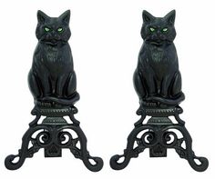 two black cat statues with green eyes sitting on top of each other's legs