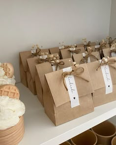 there are many small bags on the table with some cupcakes in them and one is wrapped in brown paper