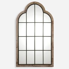 an arched window is shown with a mirror on the wall and wood frame around it