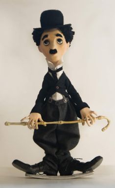 a doll is holding an umbrella and wearing a top hat