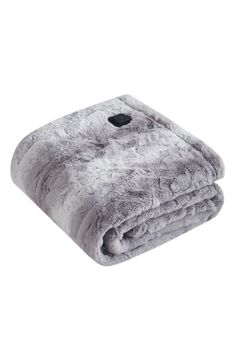 a blanket that is laying on top of a white surface with grey and black fur